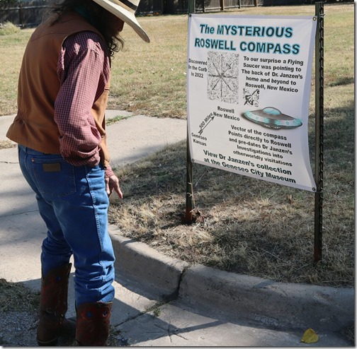 Jim Gray points to the "Roswell Compass" on the curb outside the Geneseo City Museum. Max McCoy/Kansas Reflector